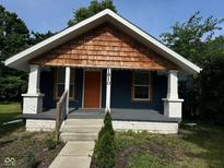 Charming home featuring cedar shake, an orange door, and a covered front porch at 1810 N Parker Ave, Indianapolis, IN 46218