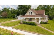 Charming vintage home featuring a welcoming front porch, a well-manicured lawn, and a detached two-car garage at 206 W Wall St, Advance, IN 46102