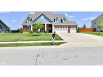 Inviting two-story brick home with a three-car garage, blue siding, and manicured lawn at 21536 Gisborne Dr, Noblesville, IN 46062