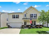 Charming two-story home with a well-maintained lawn, an American flag, and an attached two-car garage at 2282 Creekland Dr, Columbus, IN 47201