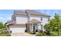 Charming two-story home with a well-manicured lawn, attached two-car garage, and inviting covered porch at 2499 Blue Ridge Dr, Greenwood, IN 46143