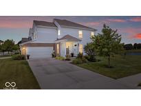 Charming two-story home with white siding, brick accents, and a well-manicured front yard at dusk at 2499 Blue Ridge Dr, Greenwood, IN 46143