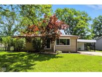 Charming single-story home with well-maintained lawn and mature trees, complemented by a convenient carport at 2811 Beech Dr, Columbus, IN 47203
