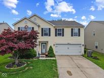 Charming two-story home with a well-manicured lawn and attached two-car garage at 3341 Carica Dr, Indianapolis, IN 46203