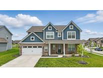 Charming two-story home with brick and blue siding, a well-manicured lawn, and an attached two-car garage at 3650 Merchmont Rd, Bargersville, IN 46106