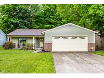 Charming single-story home with a well-manicured lawn and an attached two-car garage at 4309 Clayburn Dr, Indianapolis, IN 46268
