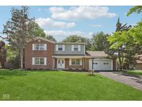 Charming two-story brick home with a well-manicured lawn and attached two-car garage at 6838 Johnson Rd, Indianapolis, IN 46220