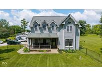 Charming two-story home with a covered porch and lush lawn, perfect for outdoor enjoyment at 7516 S County Road 300 W, Clayton, IN 46118