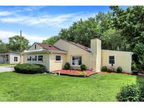 Charming home featuring professional landscaping, mature trees, and a well-maintained lawn at 8019 E Hanna Ave, Indianapolis, IN 46239
