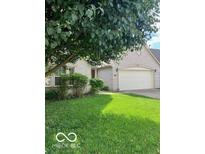 Charming brick home featuring an attached two-car garage and beautifully manicured front yard at 8326 Alcona Dr, Indianapolis, IN 46237