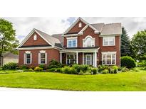 Inviting two-story brick home featuring manicured landscaping and a well-maintained lawn at 10480 Stonegate Dr, Fishers, IN 46040