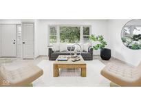Inviting living room with neutral tones, stylish furniture, a large window, and a decorative coffee table at 10778 Haverstick Rd, Carmel, IN 46033