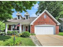 Charming brick home with well-maintained landscaping, dormer windows and an attached two car garage at 1099 Saratoga Cir, Carmel, IN 46280