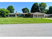 Charming single-story home with a well-manicured lawn and attached two-car garage at 136 W Loretta Dr, Indianapolis, IN 46217