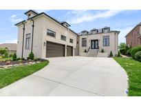 Stunning brick home with three-car garage and manicured lawn with elegant landscaping and concrete driveway at 16512 Grand Cypress Dr, Noblesville, IN 46060