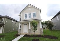 Two-story home featuring a welcoming front porch with stone accents and a well-maintained lawn at 1821 Real St, Indianapolis, IN 46240