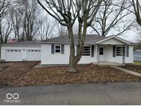 Charming single-story white home with blue shutters, large front yard, and attached garage at 200 S East St, Indianapolis, IN 46204