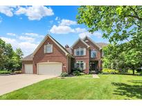 Beautiful brick two-story home featuring a manicured lawn, mature trees, and a three-car garage at 4279 Redwood Ct, Zionsville, IN 46077