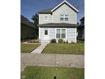 Charming two-story home featuring a well-maintained front yard with flower beds at 46 S Warman S Ave, Indianapolis, IN 46222
