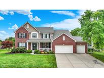 Charming two-story brick home with a well-manicured lawn and a three car attached garage at 564 Gainesway N Dr, Greenwood, IN 46142