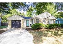 Charming home featuring a stone and vinyl exterior, inviting curb appeal, attached garage, and manicured front lawn at 5736 Primrose Ave, Indianapolis, IN 46220
