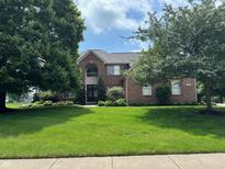 Charming brick home with a well-manicured lawn and mature trees at 5775 Coopers Hawk Dr, Carmel, IN 46033