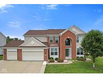Charming two-story home with a well-manicured lawn, a three-car garage and a red brick facade at 7350 Gold King Way, Indianapolis, IN 46259