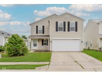 Two-story home features a two-car garage, lawn, and a welcoming front entrance at 7572 Wymm Ln, Ingalls, IN 46048