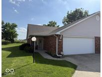 Charming brick home featuring an attached two-car garage and beautifully manicured lawn, creating a welcoming curb appeal at 989 Plaza Dr, Martinsville, IN 46151