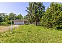 Charming single-story home with an attached garage and a lush green lawn at 10065 E 25Th St, Indianapolis, IN 46229