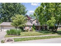 Charming two-story home with attached garage, landscaped yard, and mature trees at 11424 Green St, Carmel, IN 46033