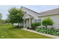 Charming home exterior with lush landscaping, including mature trees and flowering plants at 1201 Fantail Dr, Greenwood, IN 46143