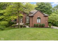 Charming brick home featuring a landscaped yard and inviting entrance at 12214 Ridgeside Rd, Indianapolis, IN 46256