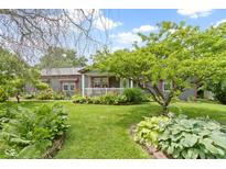 Charming home with a well-manicured front yard featuring lush greenery and colorful flowerbeds at 12222 Cable Dr, Indianapolis, IN 46236
