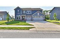Charming two-story home with a manicured lawn, a two-car garage, and inviting curb appeal at 17390 Tribute Row, Noblesville, IN 46060