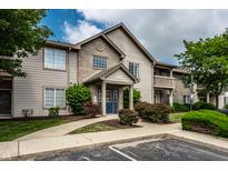 Inviting condo exterior with mature trees, landscaping, and visible parking in a well maintained community at 246 Legends Creek Way # Apt 207, Indianapolis, IN 46229