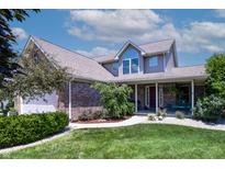 Charming two-story home featuring a manicured lawn, a brick facade and an inviting covered porch at 2756 Bluebell E Ct, Columbus, IN 47201