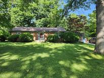 Charming brick ranch home with a lush green lawn and mature trees at 2808 Woodside Dr, Plainfield, IN 46168