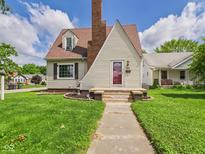 Charming Cape Cod-style home with a brick chimney, tidy landscaping, and a quaint front entrance at 328 Marine Dr, Anderson, IN 46016
