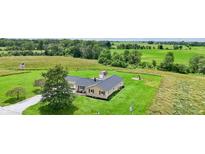 Picturesque aerial view of home with large yard, American flag and playset surrounded by beautiful greenery at 3450 Clay Rd, North Salem, IN 46165