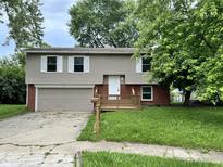 Charming two-story home featuring a welcoming front porch and attached two-car garage at 3525 Lombardy Pl, Indianapolis, IN 46226