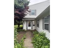Charming home entrance featuring a white door with sidelights and tidy landscaping at 4404 London Ct, Indianapolis, IN 46254