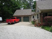 Charming home featuring a two-car garage, lovely landscaping, and a red truck in the driveway at 4521 Tulip N Dr, Martinsville, IN 46151