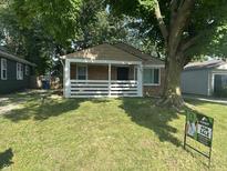 Charming single-story home featuring a cozy front porch, well-maintained lawn, and mature trees at 4723 Crittenden Ave, Indianapolis, IN 46205