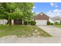 Charming brick home featuring a two-car garage and a well-manicured lawn in a quiet neighborhood at 8778 N Deer Crossing Blvd, McCordsville, IN 46055