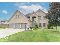 Charming brick two-story home with a well-manicured lawn and a three-car garage at 1035 White Oak Dr, Plainfield, IN 46168