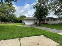 Charming single-story home featuring a one-car garage and a well-maintained lawn at 115 Hugo St, Indianapolis, IN 46229