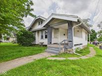 Charming single Gathering home featuring a covered porch, gray trim, and mature landscaping at 1201 Arrow Ave, Anderson, IN 46016