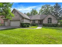 Charming brick home featuring a manicured lawn, mature trees, and an attached two-car garage at 1456 Bent Tree Pl, Greenwood, IN 46143