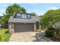 Charming home exterior featuring a gray garage door, brick accents, and lush landscaping at 19522 Diamond Way, Noblesville, IN 46062